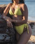 Woman wearing Azalea Bottom in yellow, featuring high waisted, high leg cut, cheeky coverage, and adjustable lacing on the sides for a perfect fit.